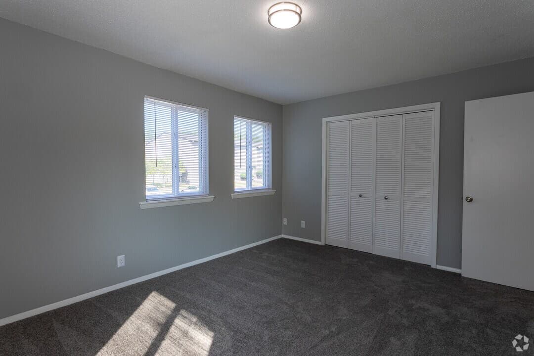 Spacious carpeted bedroom with natural light