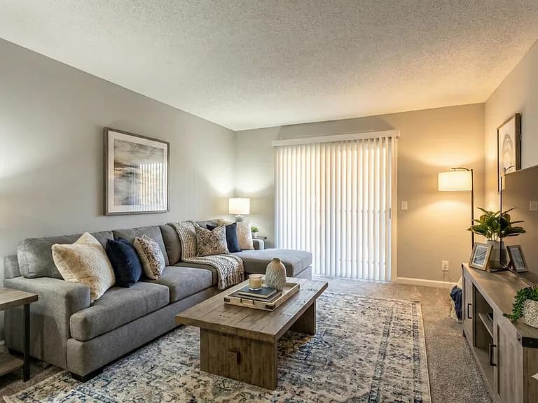 Spacious staged living room with sectional sofa and patio access